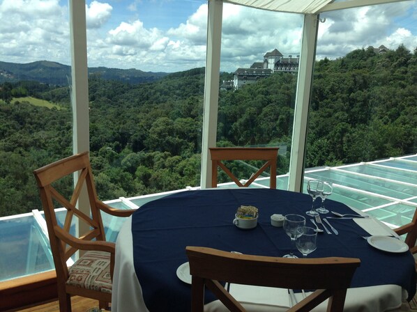 Una mesa lista para comer, con vistas a una colina boscosa y un castillo a lo lejos.