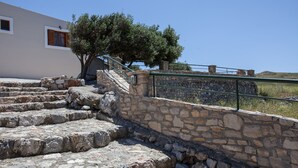 Un escalier en pierre mène à un bâtiment, avec un arbre à côté.
