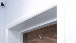 A wooden door with a number 7, white walls, and a visible door handle. - Spring Bank ApartHotel (Preston)