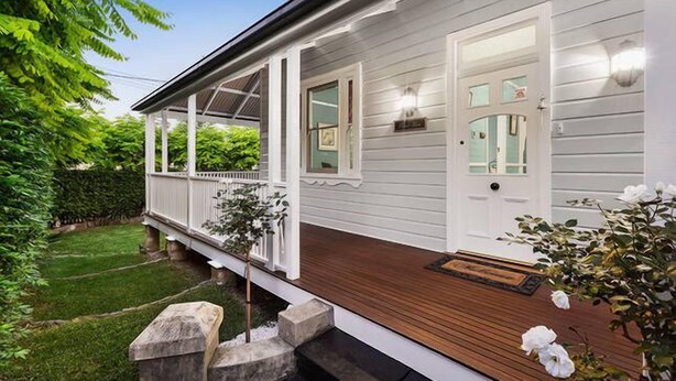 A house with a covered porch, a front door, and a small front yard.