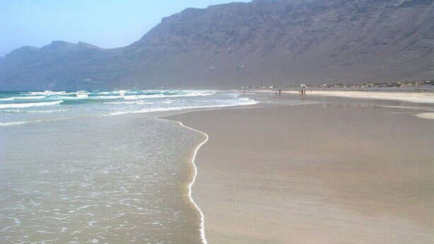 Una playa con una montaña al fondo.