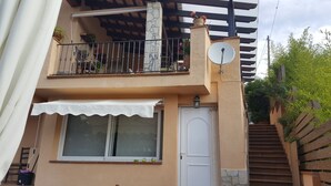 A two-story building with a balcony, a satellite dish, and a white awning. - Blanes: beautiful house with pool and garden (Blanes)