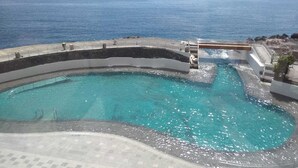 A large, curved swimming pool with a view of the sea. - Apartment in 1 sea line (tabaiba)