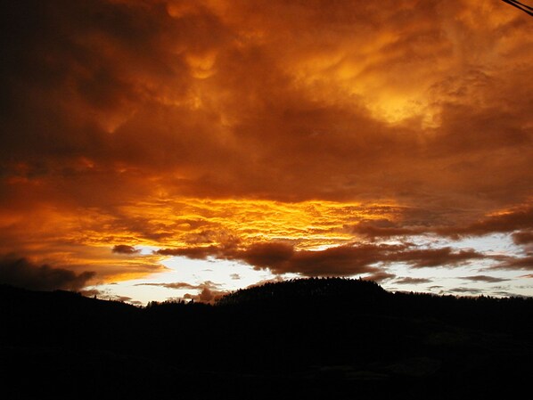 Un coucher de soleil sur une chaîne de montagnes, avec des nuages.