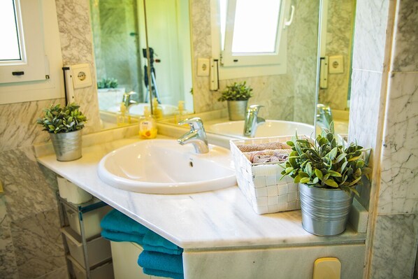 A bathroom with a marble sink, two faucets, a mirror, and potted plants. - Villa in first line, garden, barbecue, ideal for families. (La Chullera)