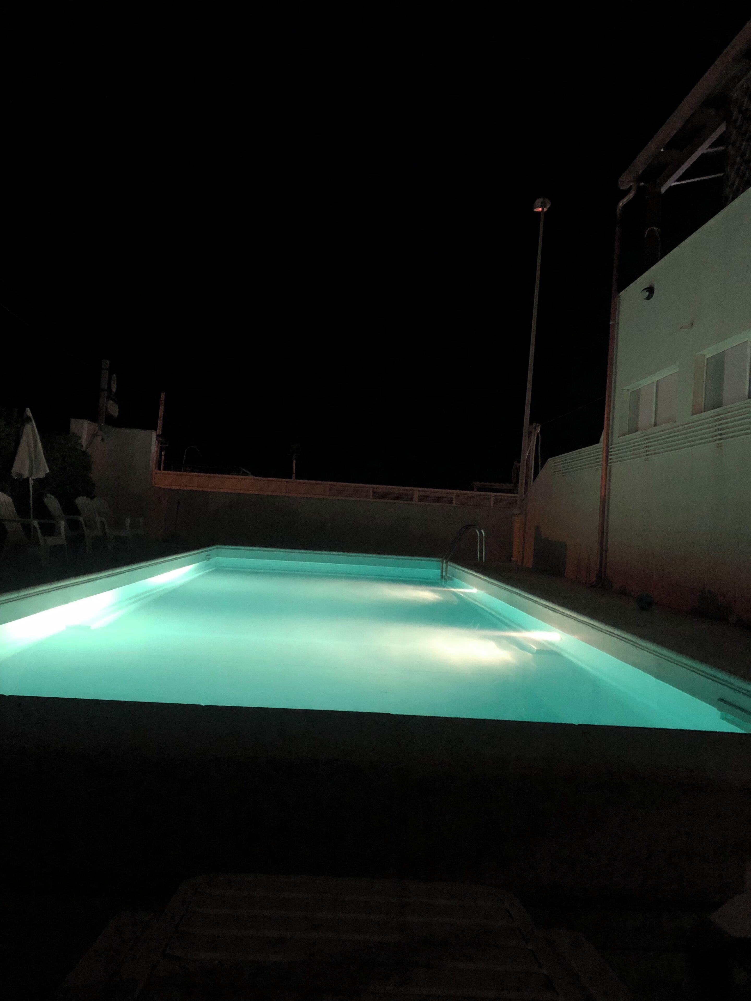 En säsongsöppen utomhuspool, parasoller och solstolar