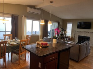 Enjoy a comfortable stay in this well-appointed living space with a central island, dining area, and cozy fireplace.