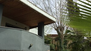 A building with a curved facade, a wooden overhang, and a tiled border. - All - in! Villa with view, pool, quiet and private. Last-minute in september (Tordera)