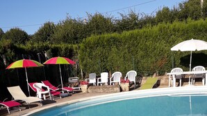 En swimmingpool med liggestole og parasoller.