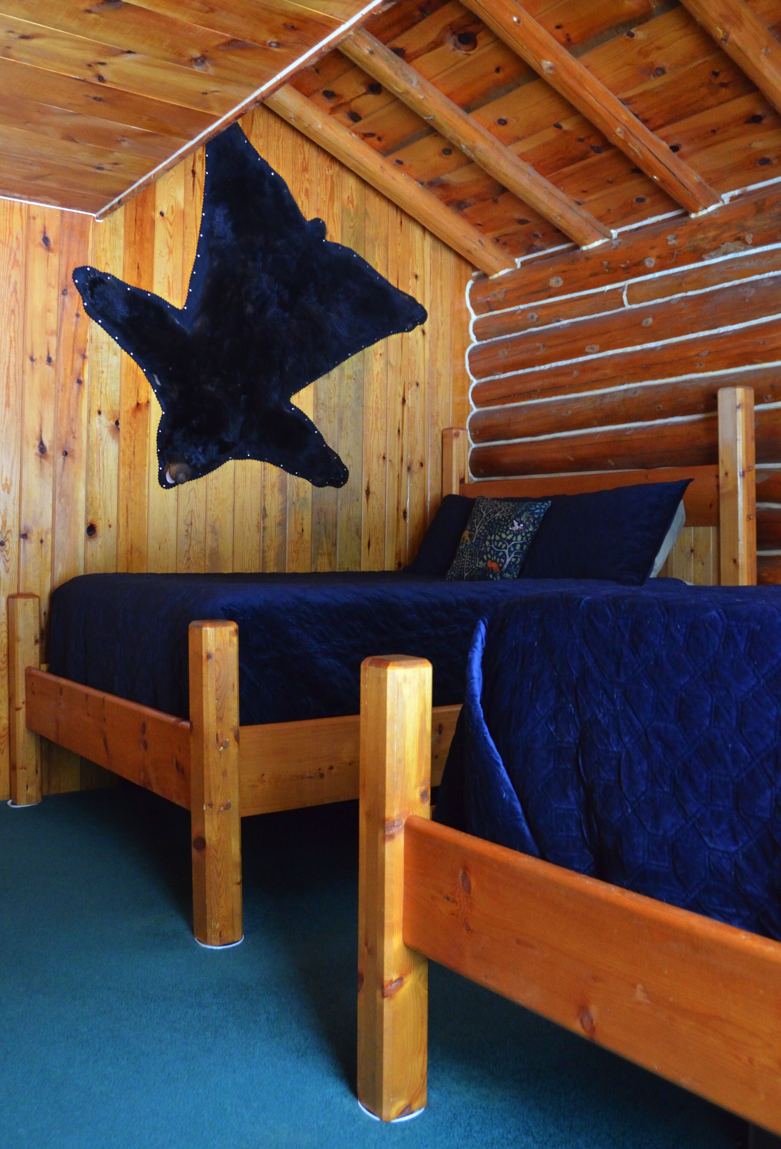 A wooden cabin bedroom with a bed, a star decoration, and a wooden headboard.