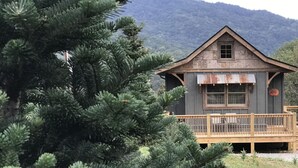 Un chalet rustique doté d’une terrasse en bois et surplombant une chaîne de montagnes.