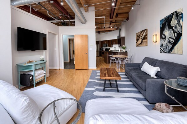 A modern living space with a sofa, coffee table, and a TV mounted on the wall.