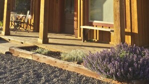 A two-story wooden cabin with a balcony, large windows, and a number '400' on the side. - Award Winning Cow Creek Suite: Edge-Of-Town Quiet & Convenience With Great Views (Ridgway)