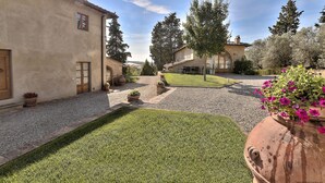 A courtyard with a paved area, potted plants, and a grassy lawn. - Luxury Villa: Air-Co & Swimmingpool in Chianti/Sleeps 21 or more in extra suites (Montespertoli)