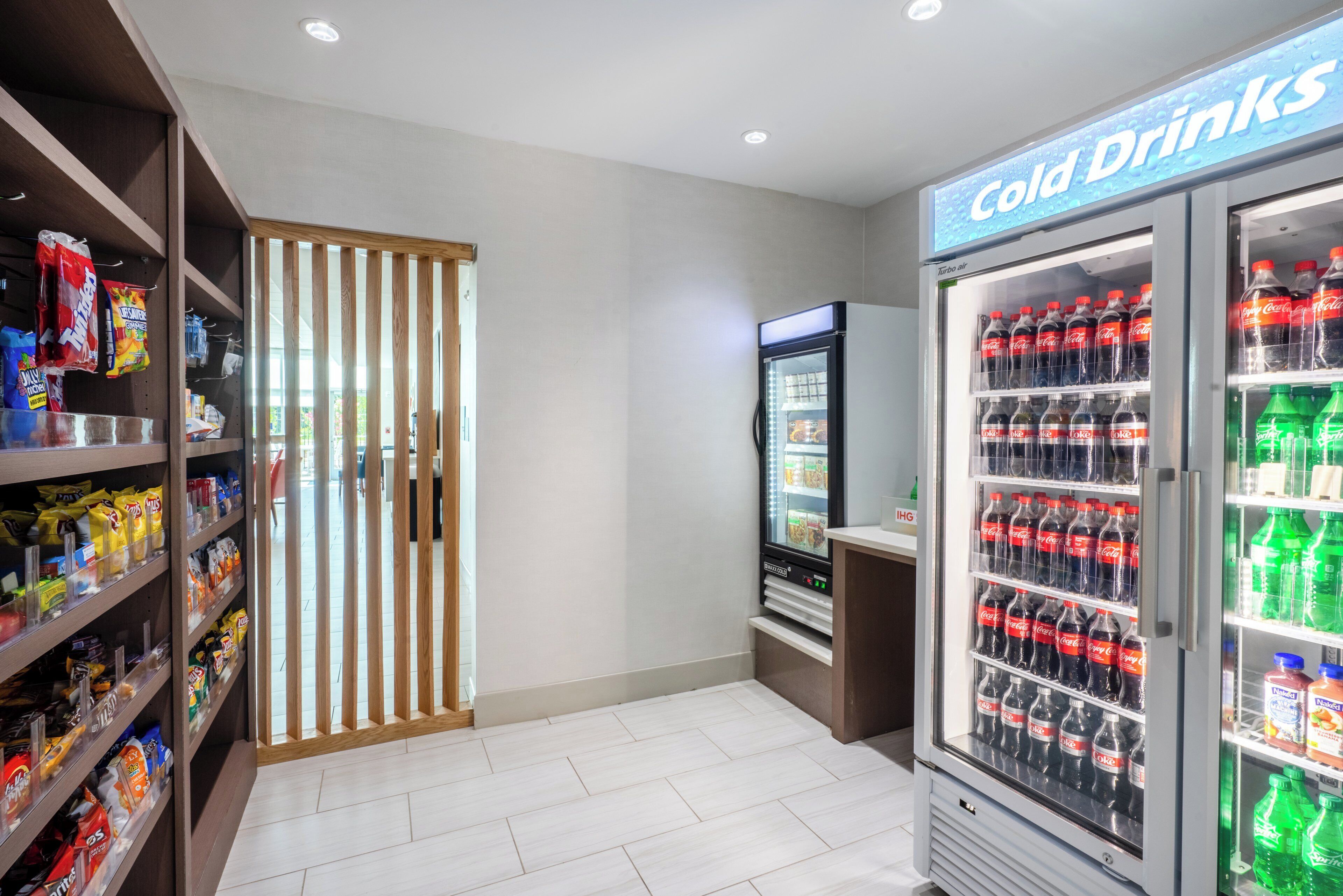 A snack and cold drink vending area with various snack bags and bottled beverages.
