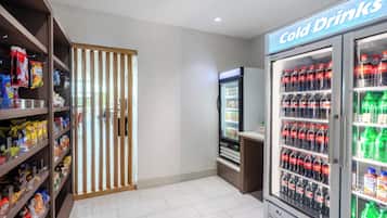 A snack and cold drink vending area with various snack bags and bottled beverages.