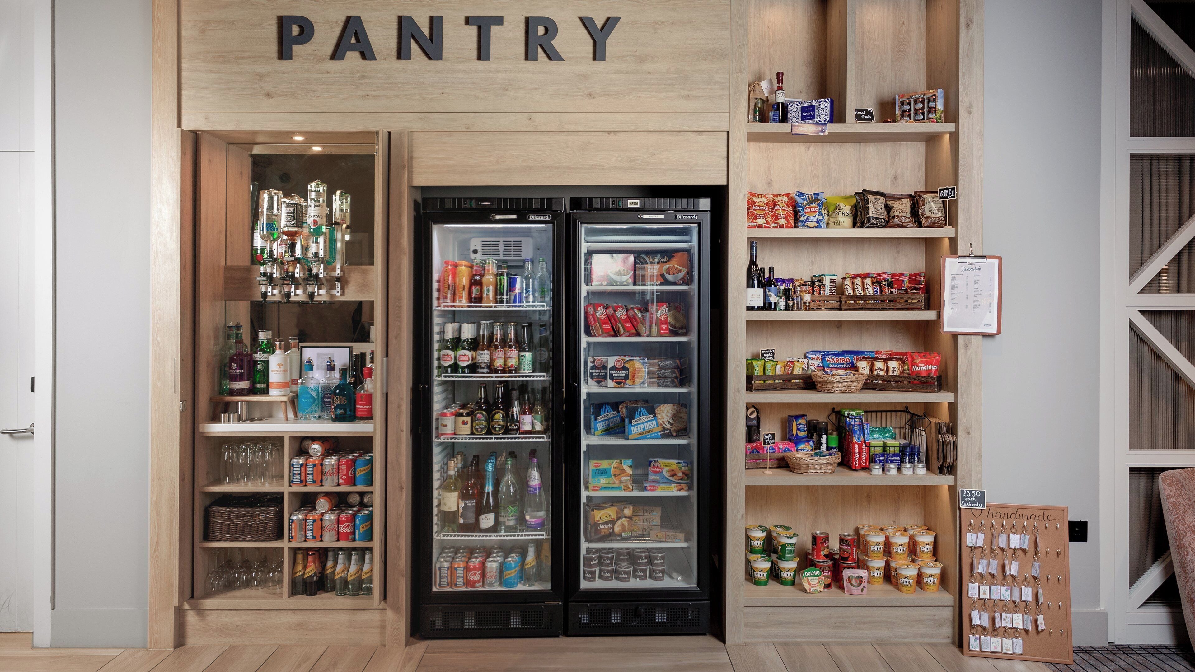 A pantry area with shelves stocked with snacks, beverages, and condiments.