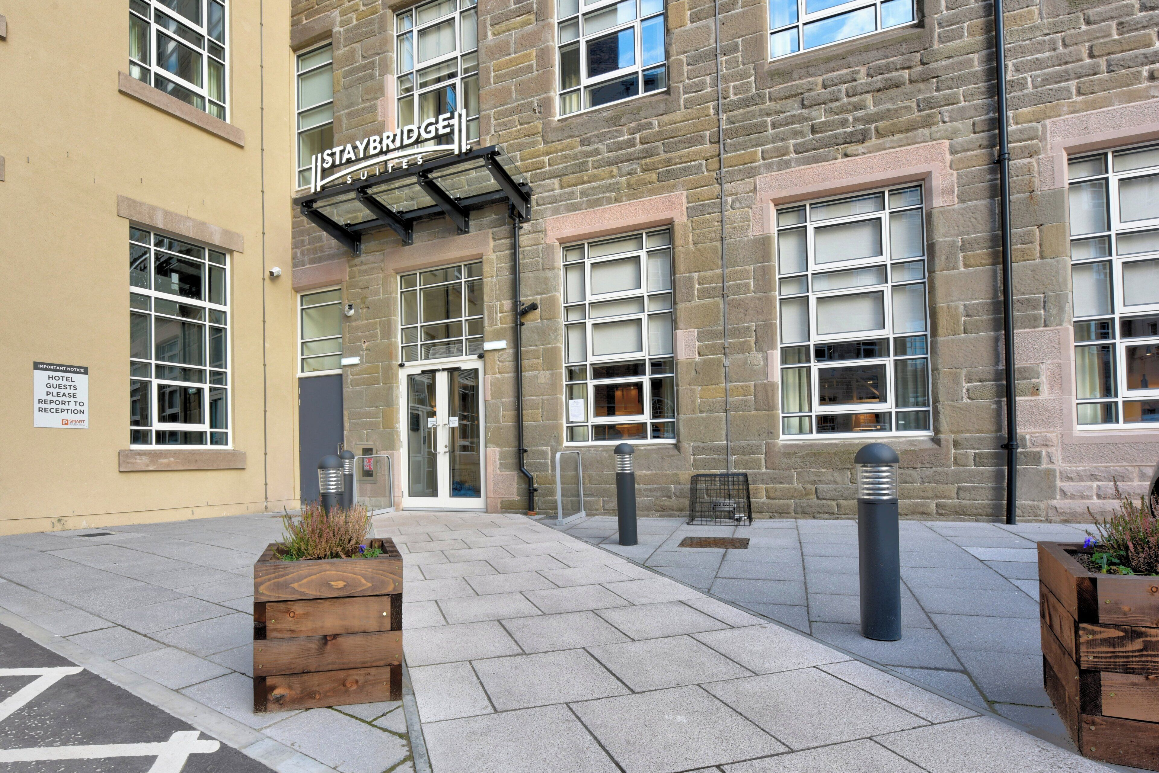 A hotel entrance with a sign reading 'Staybridge Suites'.