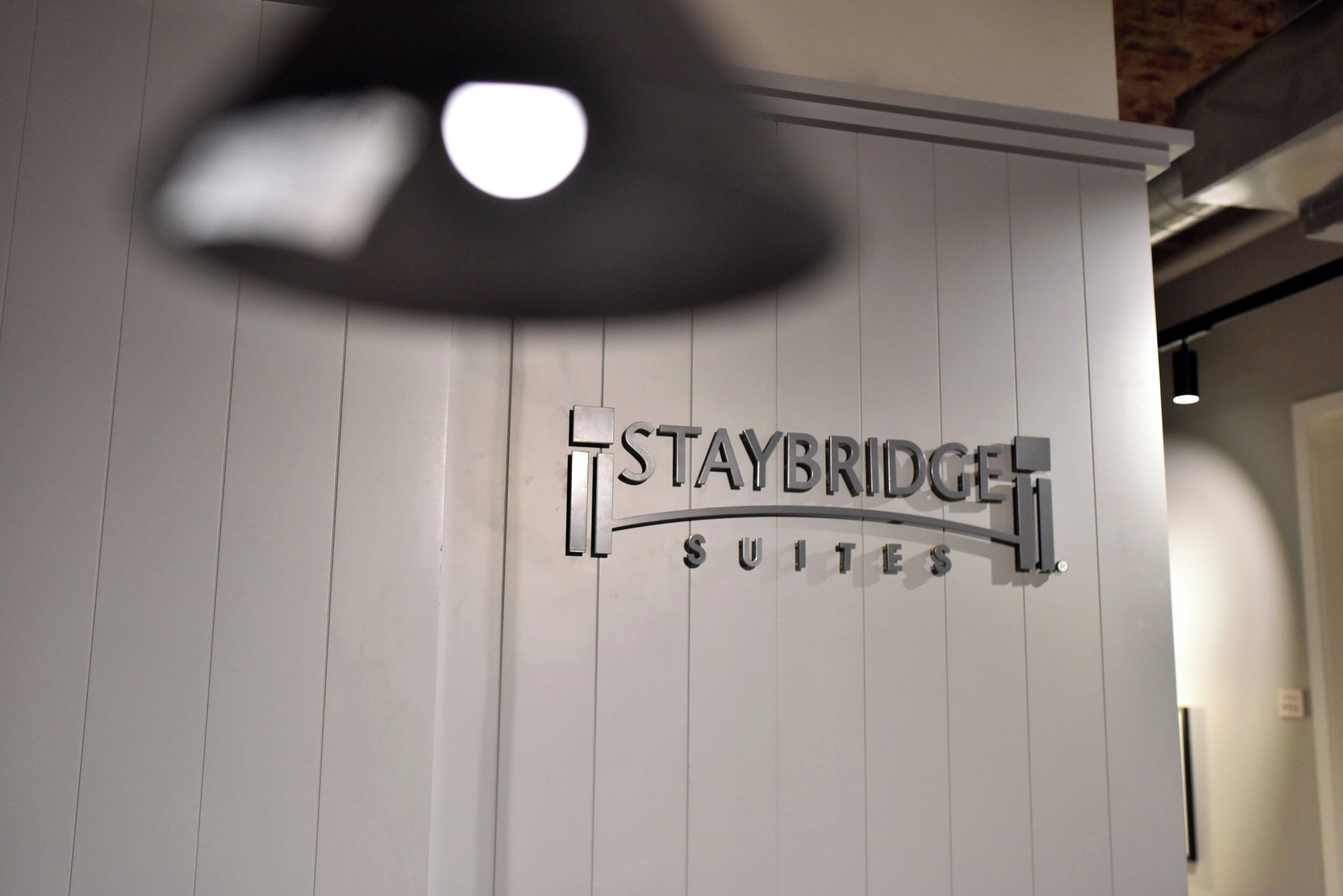 A sign for Staybridge Suites with a modern design and a clean, white background.