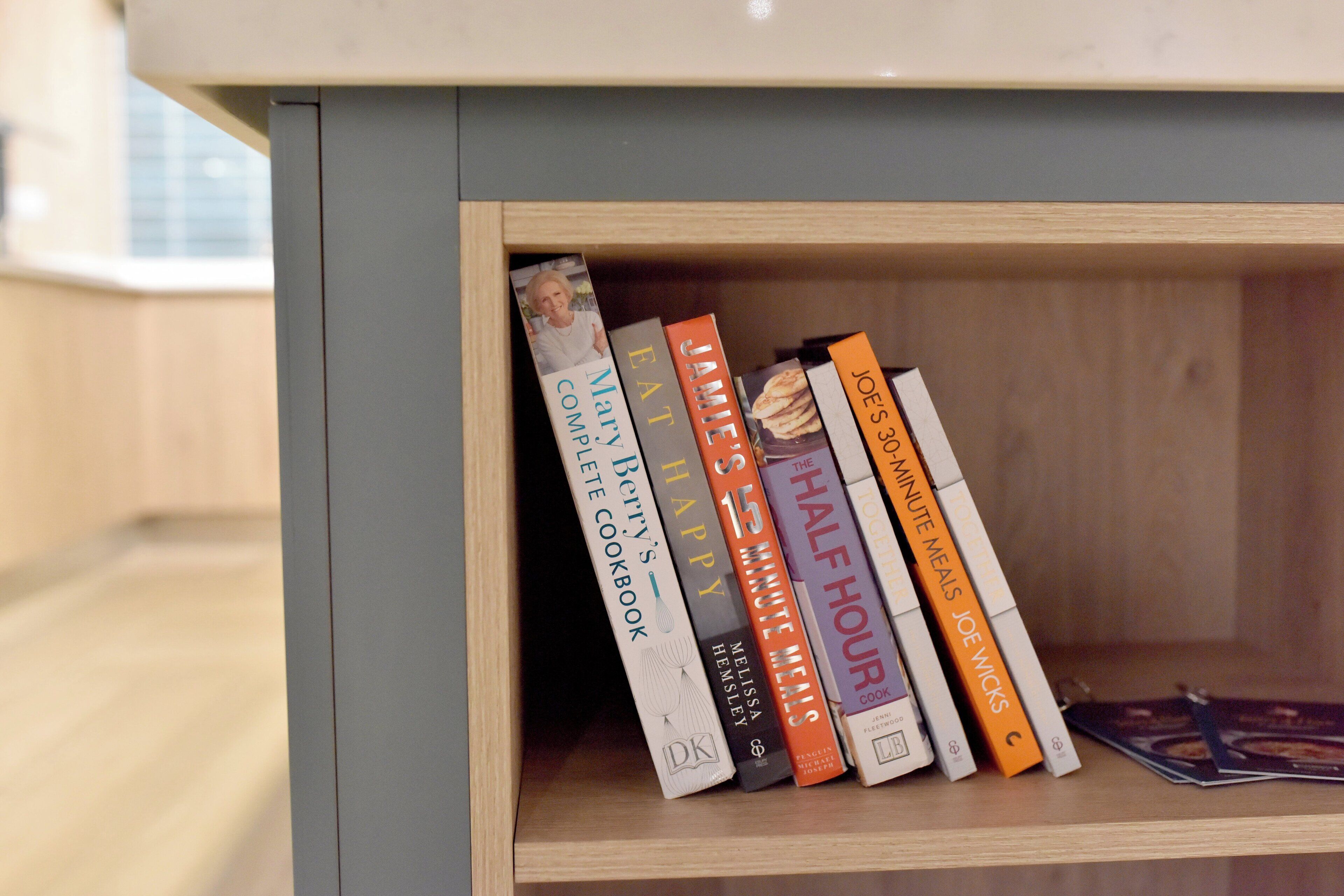 A bookshelf with several cookbooks.