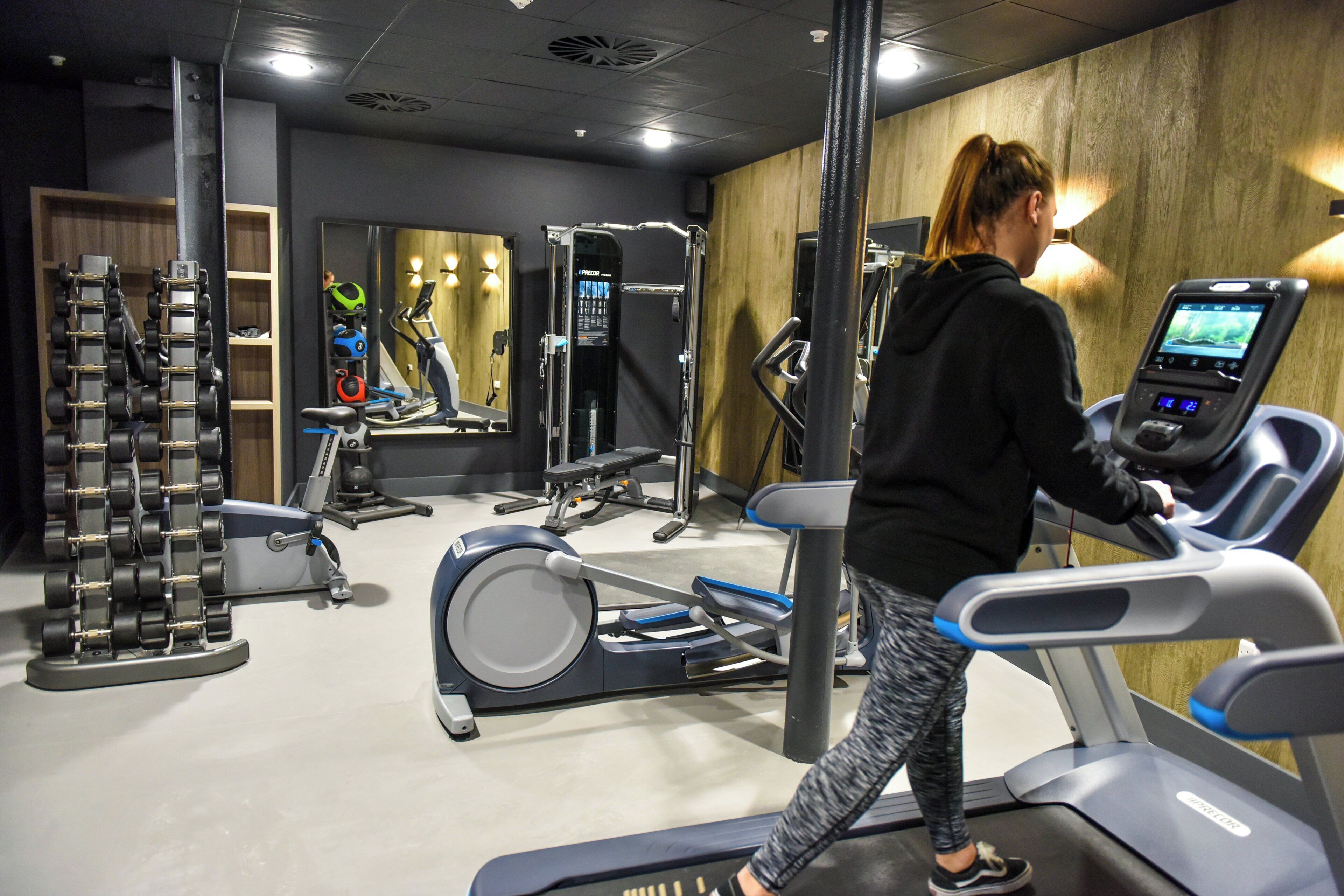 A gym with treadmills, weight machines, and free weights.