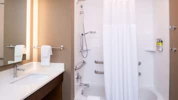 A modern bathroom with a sink, mirror, and shower.