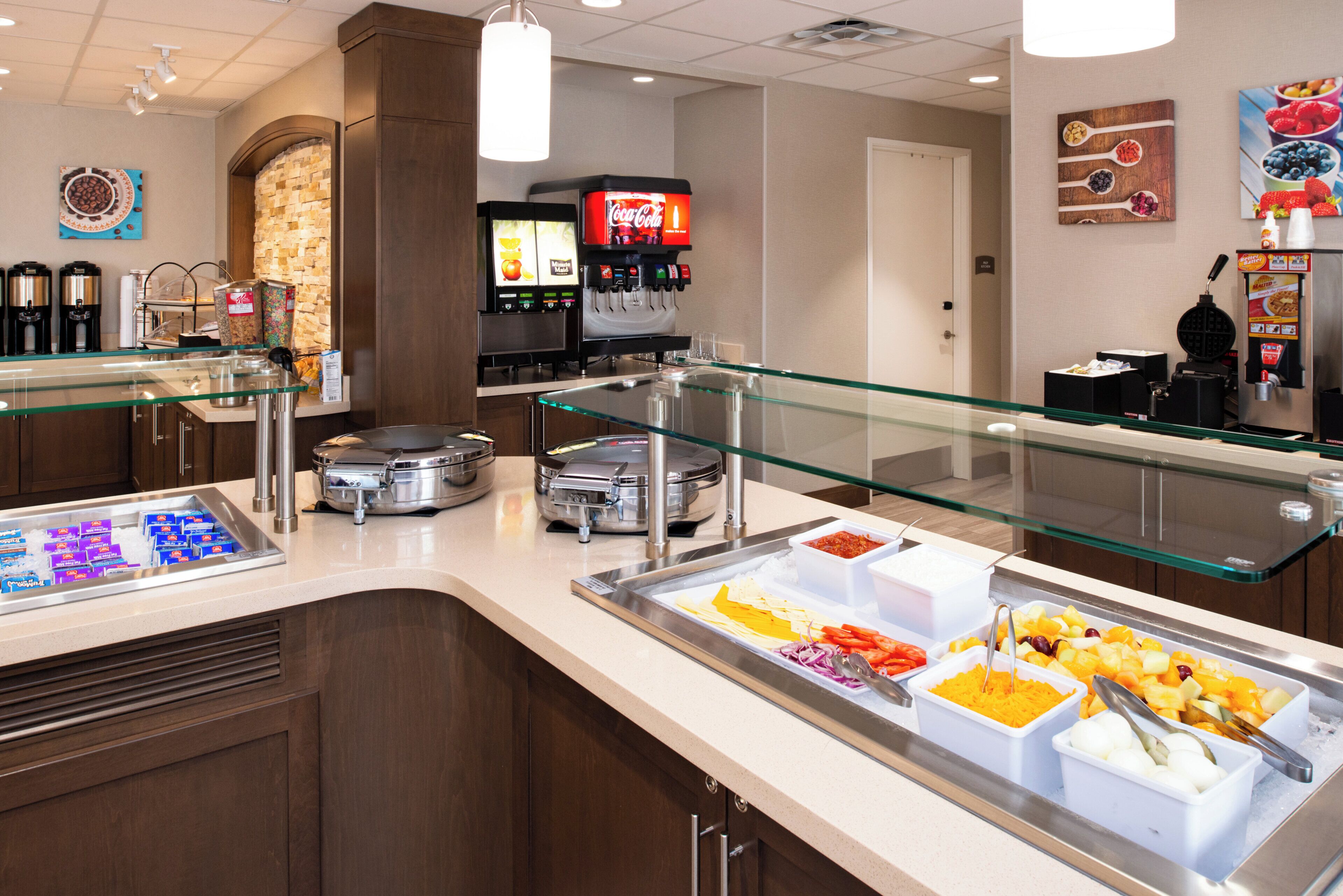 A buffet area with various food stations, including a coffee station and a beverage dispenser.