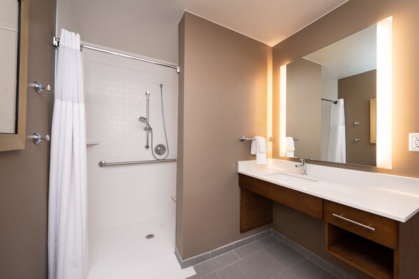 Un baño moderno con ducha, lavabo y espejo.