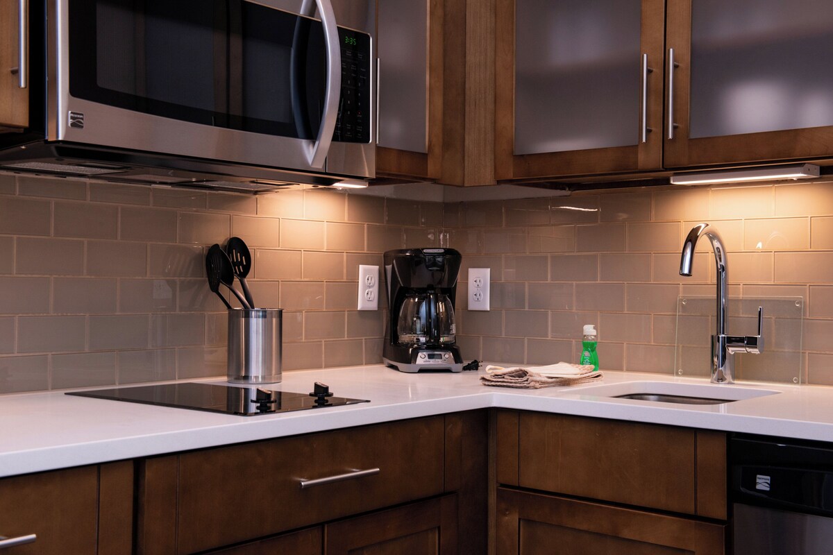 A kitchen with a microwave, coffee maker, and sink.