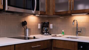 A kitchen with a microwave, coffee maker, and sink.