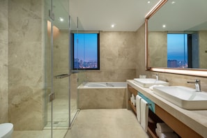A modern bathroom with a glass-enclosed shower, a bathtub, and two sinks. - Holiday Inn Tianjin Xiqing by IHG (Tianjin)