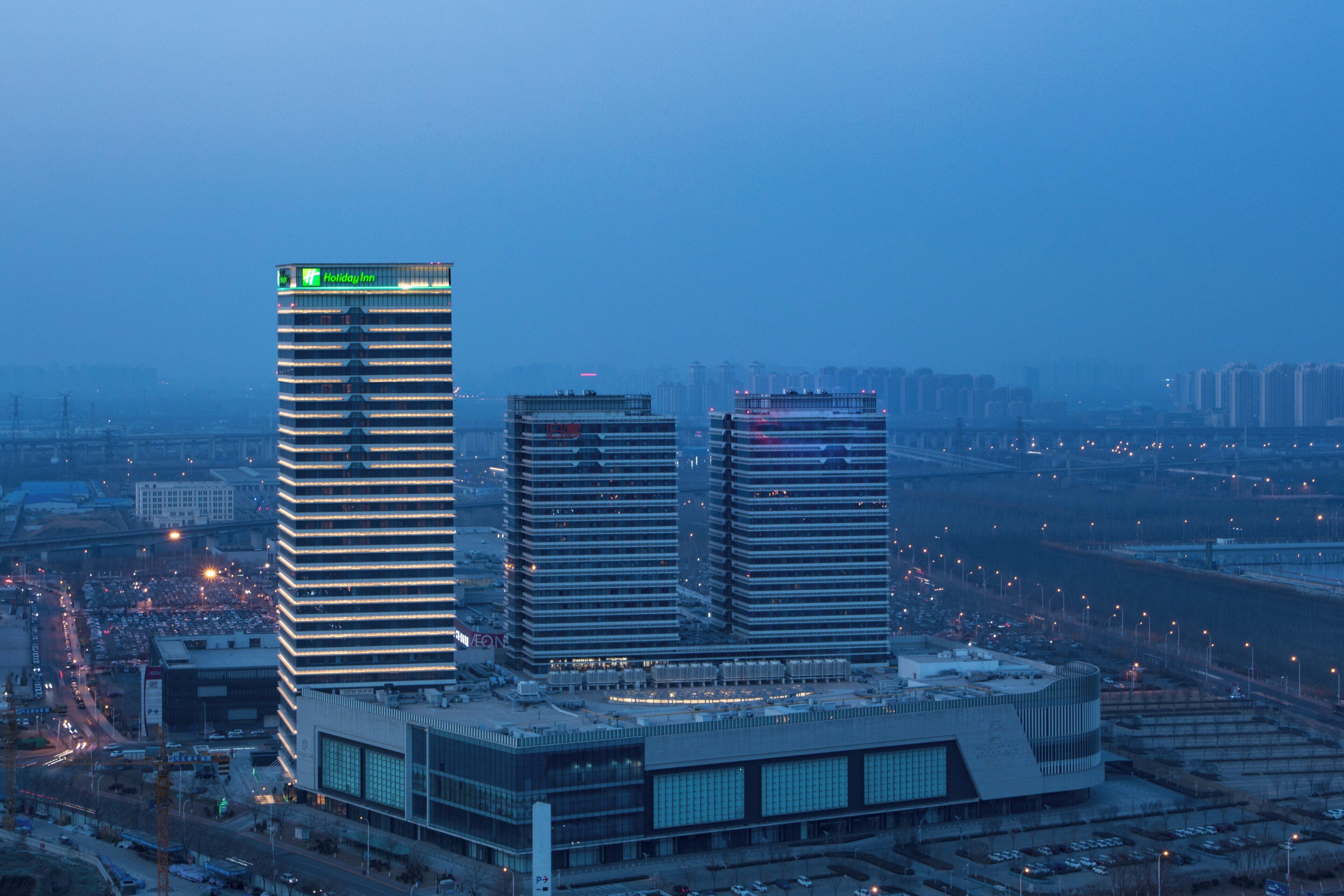 A modern hotel complex with multiple high-rise buildings, featuring a prominent Holiday Inn sign.
