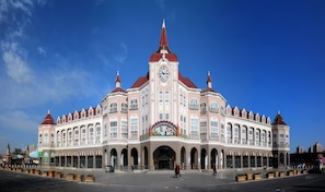 A large, historic building with a central clock tower, multiple arches, and a prominent entrance with decorative elements. - Holiday Inn Tianjin Xiqing by IHG (Tianjin)