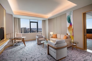 A hotel room with a large window, a sofa, a chair, a small table, and a TV. - Holiday Inn Tianjin Xiqing by IHG (Tianjin)