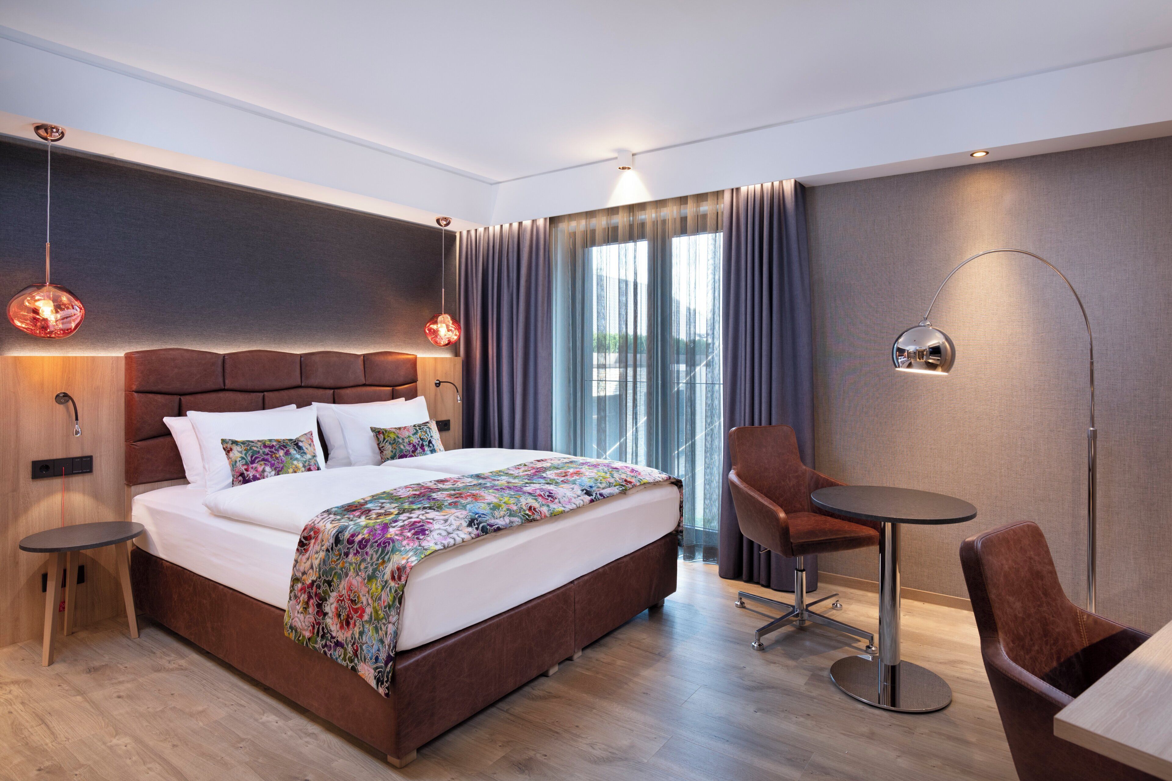 Una habitación de hotel moderna con una cama grande, un escritorio y una silla.