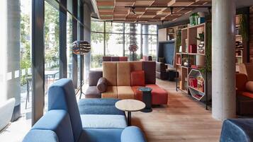 Un intérieur moderne avec un canapé d’angle, une table basse ronde et une bibliothèque.