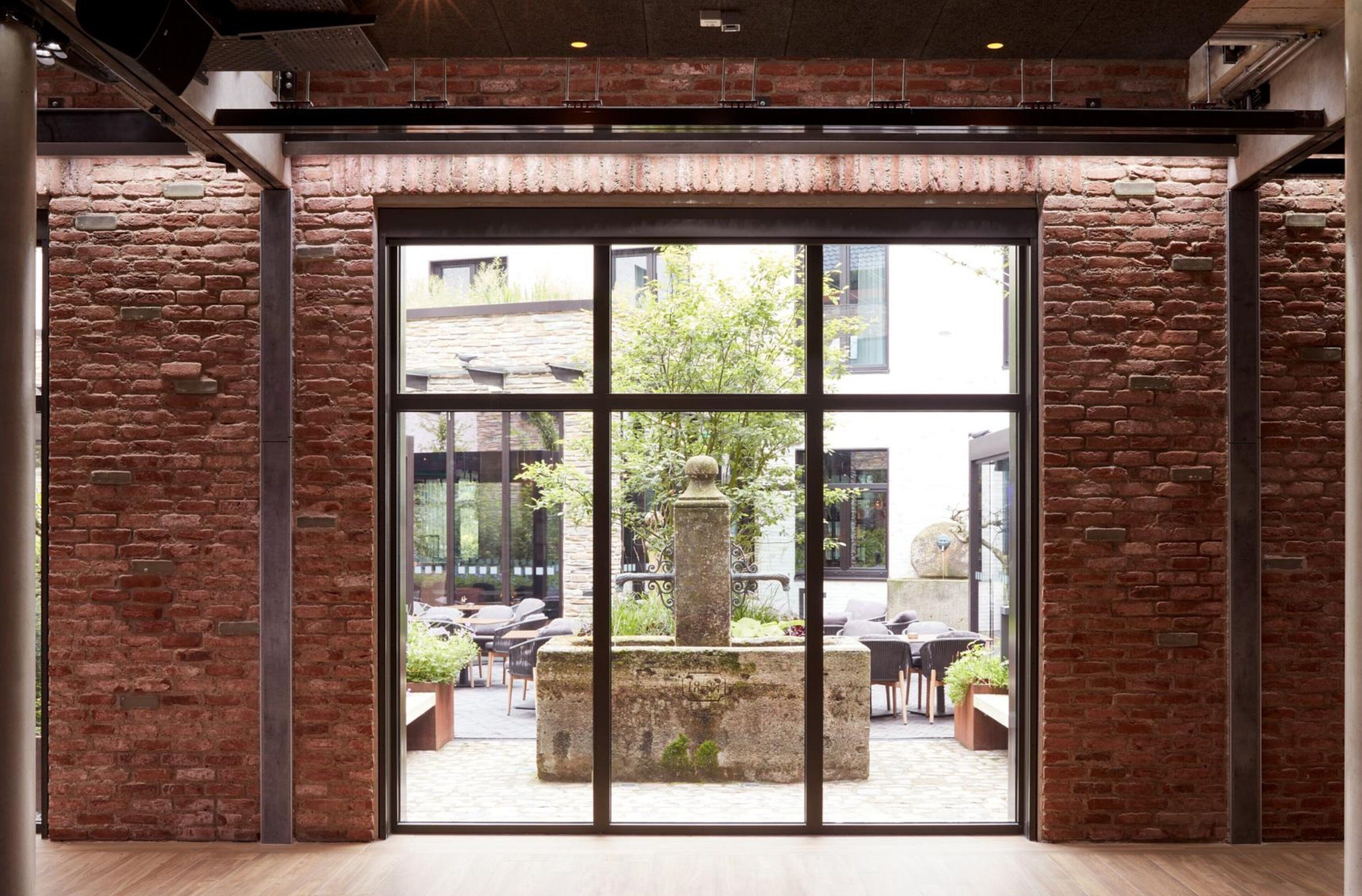 A spacious room with large windows and a view of an outdoor patio area.