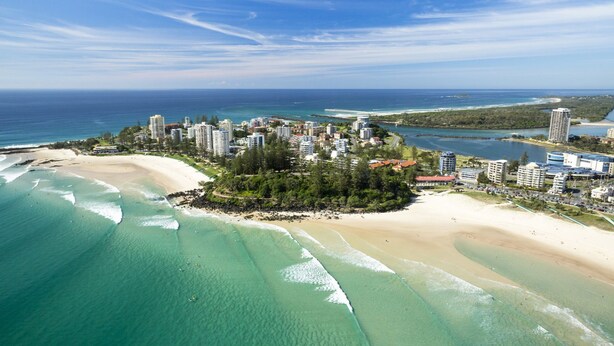 A coastal resort with beachfront properties, clear blue waters, and a mix of high-rise and low-rise buildings.