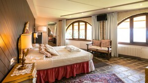 A bedroom with a bed, a chair, a nightstand, a lamp, and a window with curtains. - Villa immersed in the nature, relax and privacy, private pool and garden (Castiglion Fiorentino)