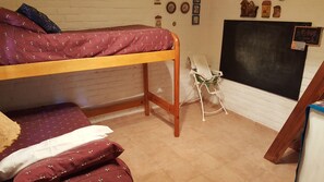 Un dormitorio con literas, un escritorio, una silla y una pizarra.