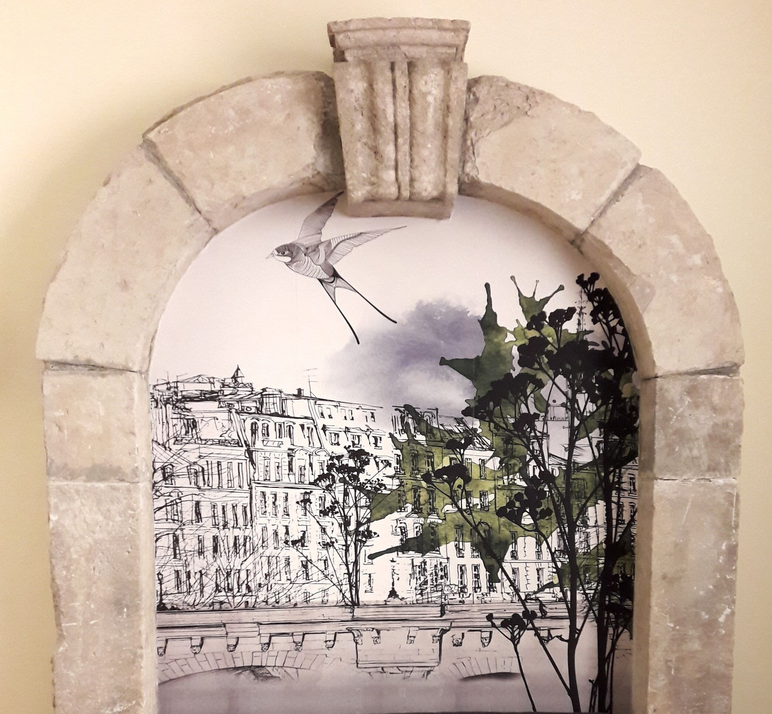 A mural of a bird flying over a cityscape with buildings and a bridge.