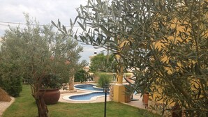 A courtyard with a swimming pool, surrounded by olive trees and a yellow building. - Luxury villa with private swimming pool near Carvoeiro (Carvoeiro)