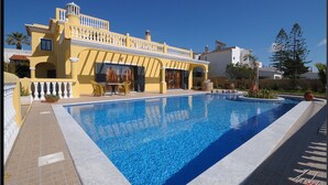 A large swimming pool with a yellow building in the background. - Luxury villa with private swimming pool near Carvoeiro (Carvoeiro)