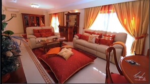 A living room with two sofas, a coffee table, and a dining table. There is a bookshelf and a plant in the room. - Luxury villa with private swimming pool near Carvoeiro (Carvoeiro)