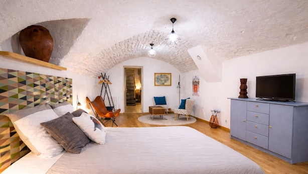 A bedroom with a large bed, a television, a cabinet, and a chair.