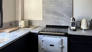 Una cocina con extractor Bosch, estufa, tostadora y hervidor.