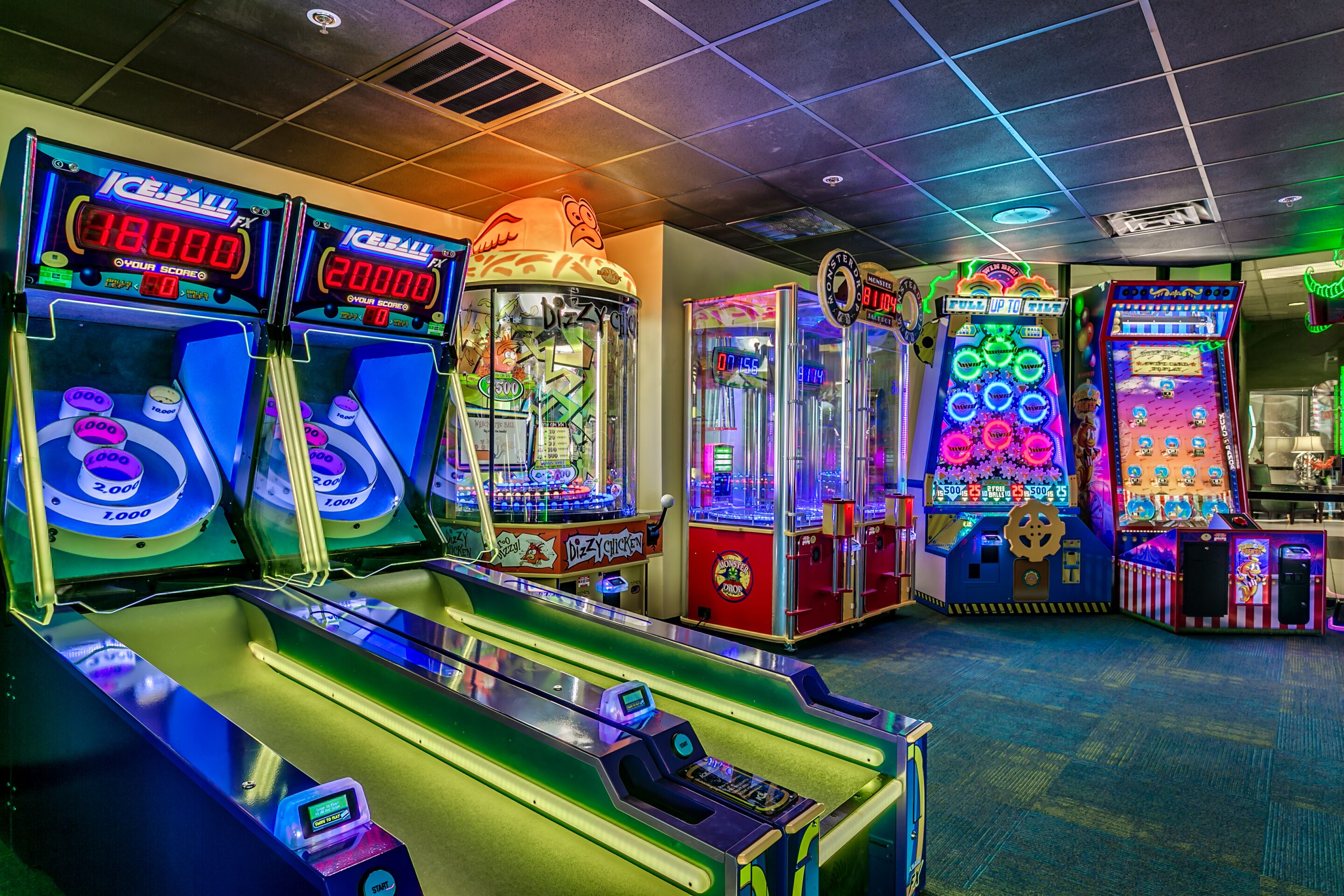 Una hilera de juegos de arcade con pantallas de puntaje y luces de colores.