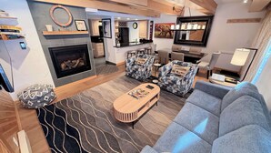 A modern living room with a fireplace, sofas, and a dining area. - Remodeled Condo with Fireplace - In unit Washer/Dryer (Vail)
