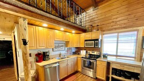 Una cocina con armarios de madera, electrodomésticos de acero inoxidable y un cartel de bienvenida.