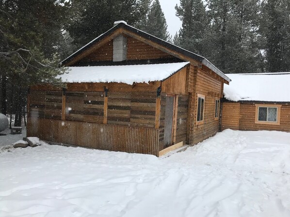 A wooden cabin with a snow-covered roof and a log wall, surrounded by trees. - 18 miles to Yellowstone Park! Golf, Snowmobile or ATV from front door! (Island Park)